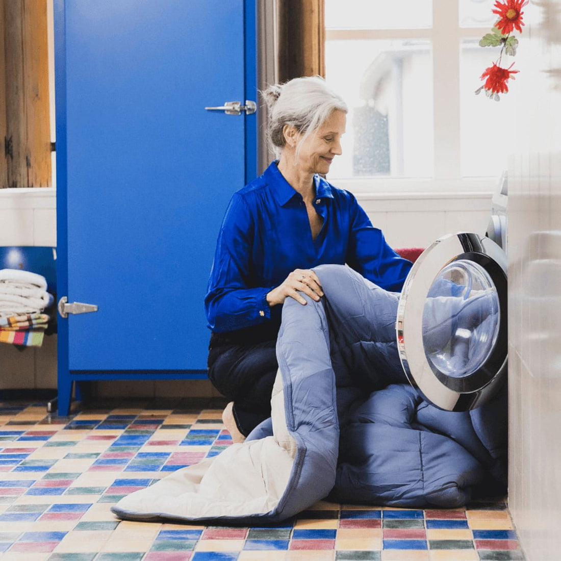 Vrouw stopt dekbed in de wasmachine