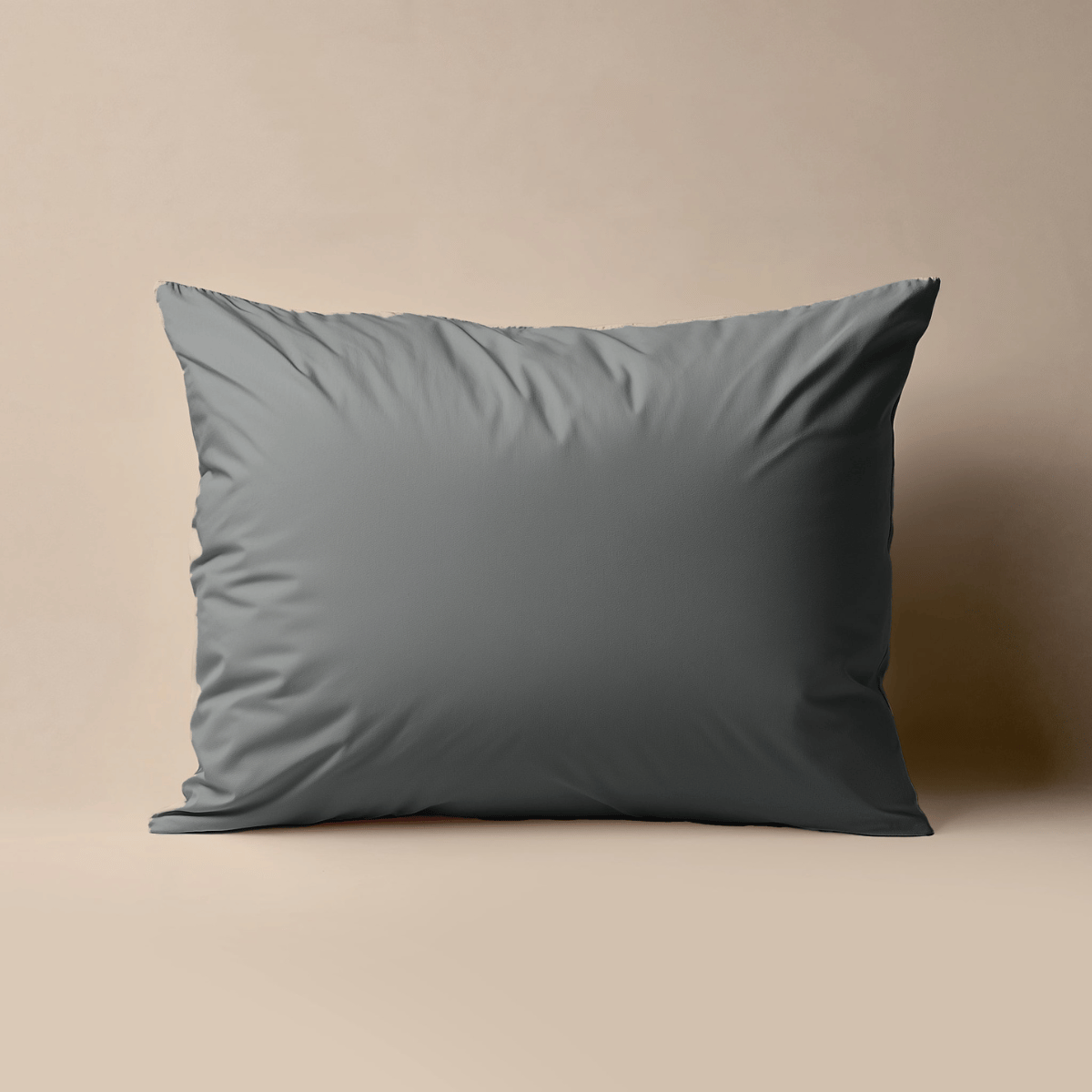 De Zelesta Premiumbed Kussensloop Set van 2 in antraciet, gemaakt van percale katoen, staat rechtop tegen een neutrale beige achtergrond voor een luxe slaapervaring.