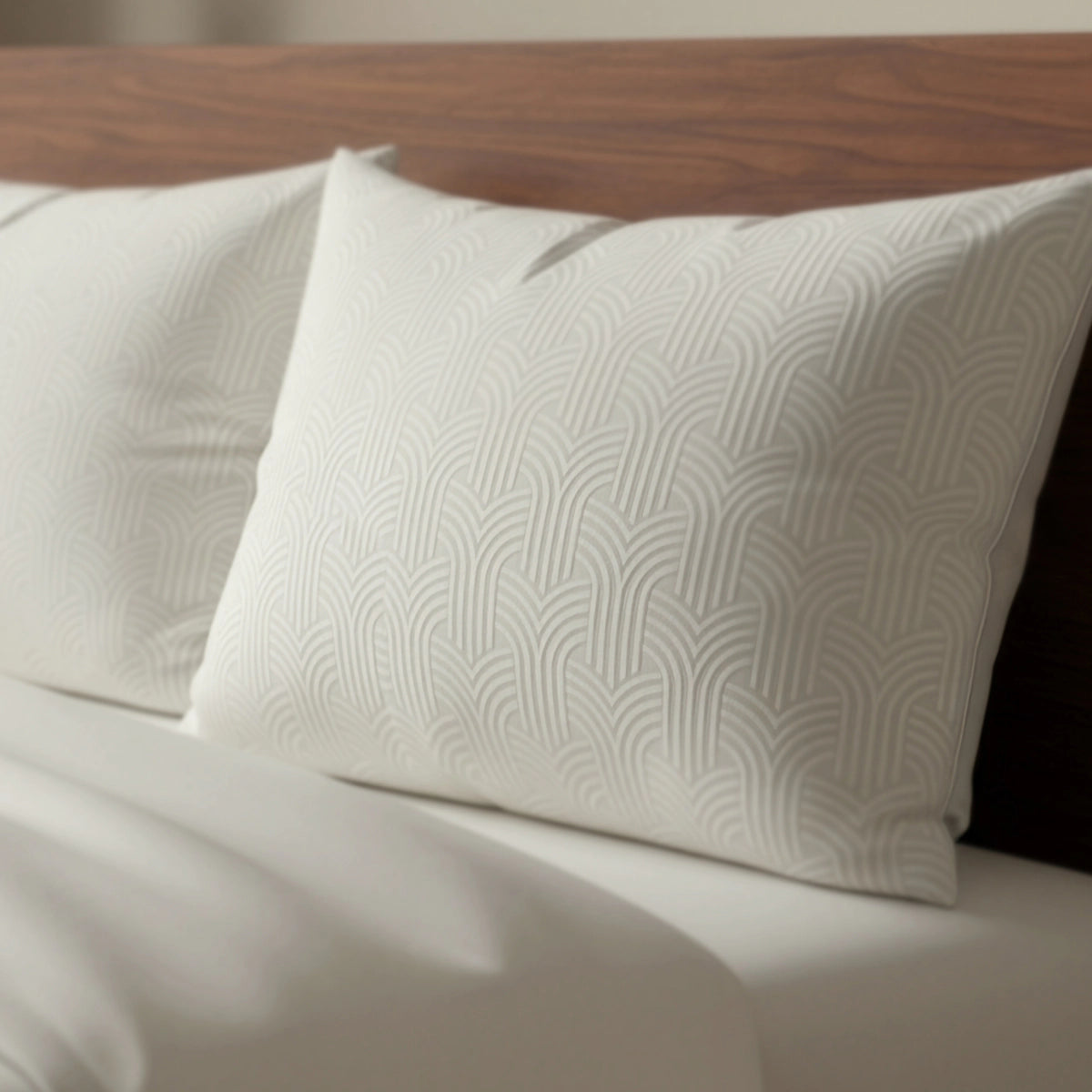 Twee Zelesta Flanel Art kussenslopen set van 2 in crème met geometrisch patroon en luxe rits liggen tegen een houten hoofdbord op een netjes opgemaakt bed.