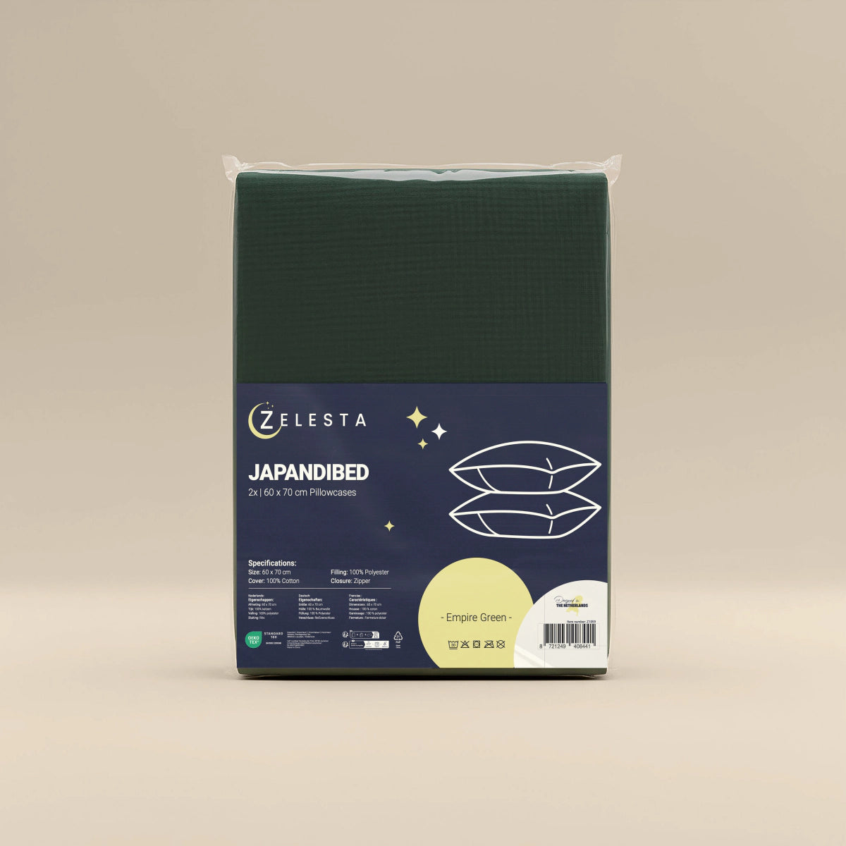 Een set Japandibed Katoen Mousseline Kussenslopen van 2 in Green van Zelesta (60x70cm) staat rechtop tegen een effen beige achtergrond, gemaakt voor ultiem comfort van zachte katoen mousseline.