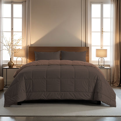 Een netjes opgemaakt bed met het Zelesta Comfort Duo Dekbed in chocolade bruin & mokka en bijpassende kussens, geflankeerd door twee nachtkastjes met lampen, in een kamer met grote ramen en beige gordijnen. Perfect voor comfort het hele seizoen door.