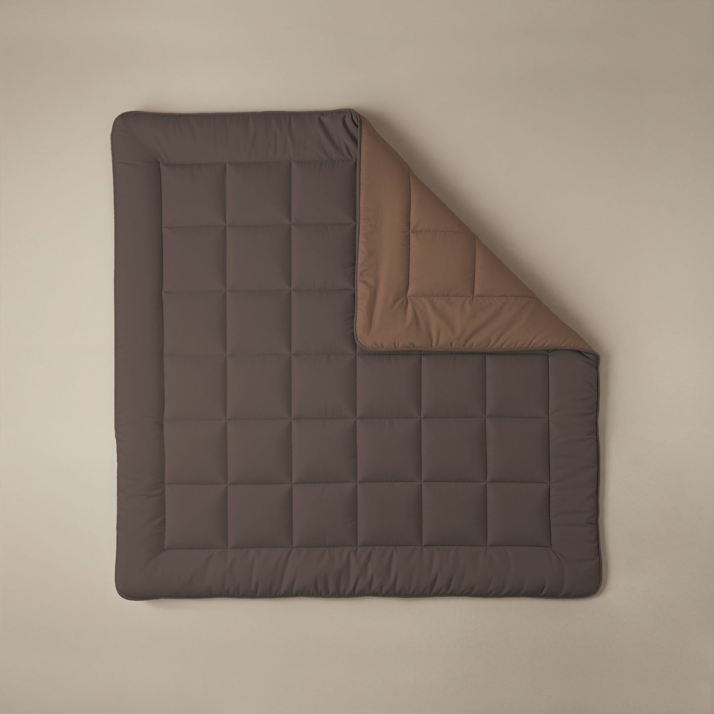 Het Zelesta Comfort Duo Dekbed in chocoladebruin met een omgeslagen hoek die de mokka onderkant laat zien, rust op een neutrale achtergrond - een klassieker voor elk seizoen, geïnspireerd op traditionele dekbedden.