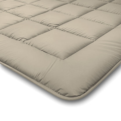Close-up van het Zelesta Comfort Duo Dekbed in taupe & champagne, met gewatteerde vierkante stiksels en pluche vulling - een ideale topper voor alle seizoenen - getoond op een witte achtergrond.