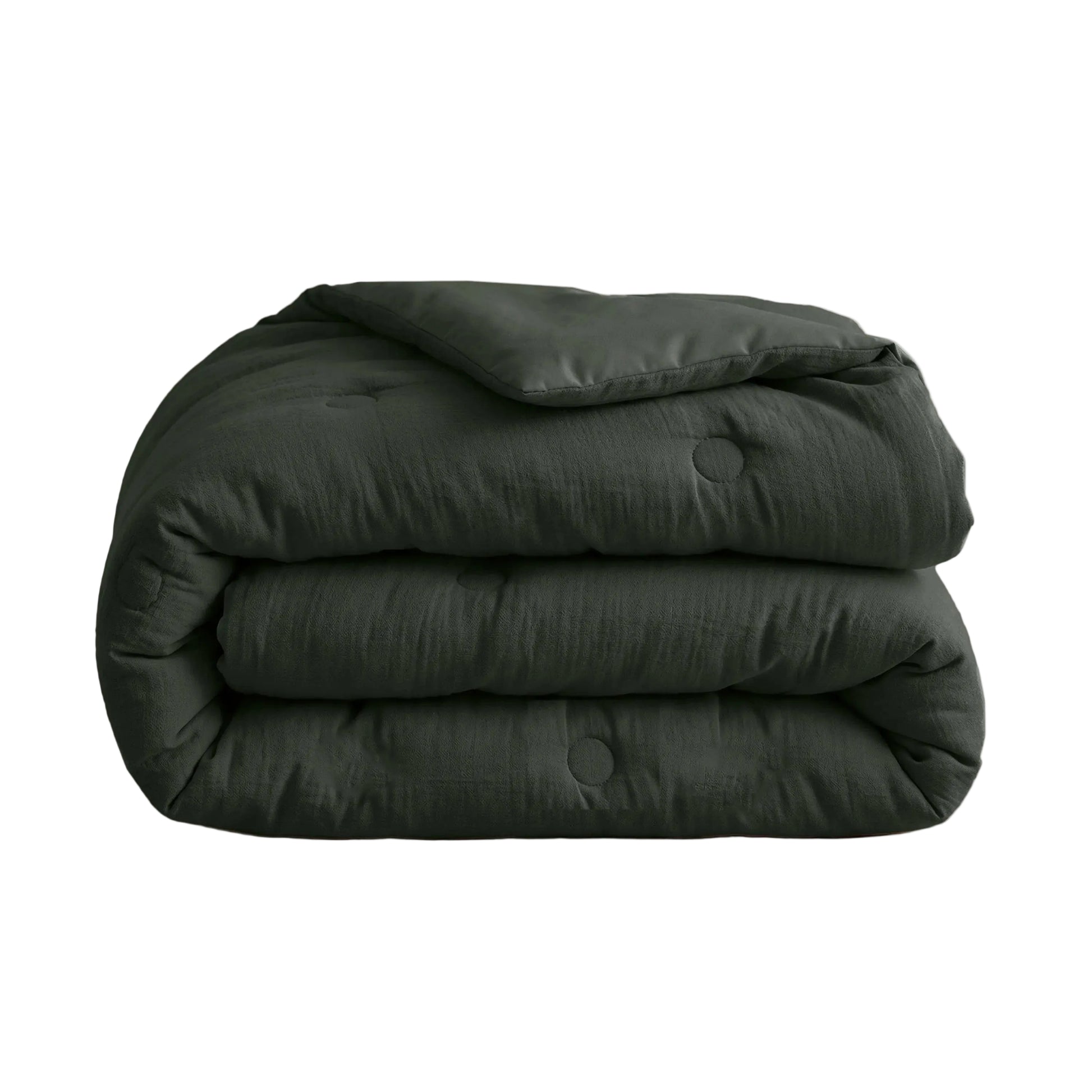 De Zelesta Japandibed Katoen Mousseline - Groen is een donkergroen, doorgestikt Japandi dekbed van dubbelgeweven katoen, netjes opgevouwen op een witte ondergrond.