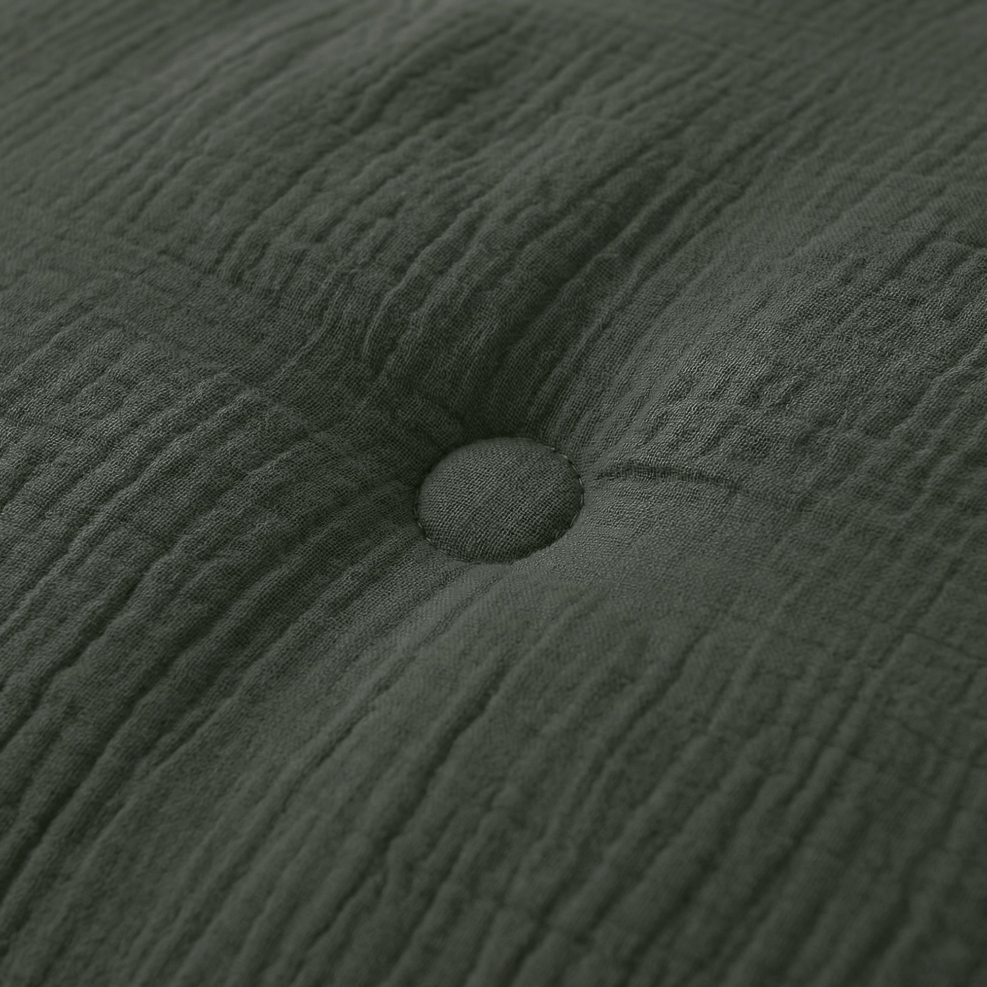 Close-up van het Zelesta Japandibed Katoen Mousseline kussen in donkergroen, met dubbelgeweven katoen en een centrale knoop voor een luxe, getextureerde afwerking.