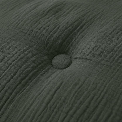 Close-up van het Zelesta Japandibed Katoen Mousseline kussen in donkergroen, met dubbelgeweven katoen en een centrale knoop voor een luxe, getextureerde afwerking.
