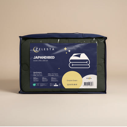 Een verpakte Zelesta Japandibed Katoen Mousseline - Groen, 240 x 200 cm, verschijnt in een marineblauwe tas met productinformatie en een eenvoudige dekbedillustratie op het label, gemaakt van dubbelgeweven katoen voor extra zachtheid.