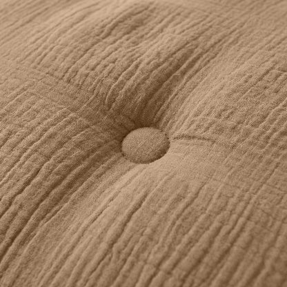 Close-up van het Zelesta Japandibed Katoen Mousseline kussen in bruin, met beige mousseline stof en een enkele centrale knoop.