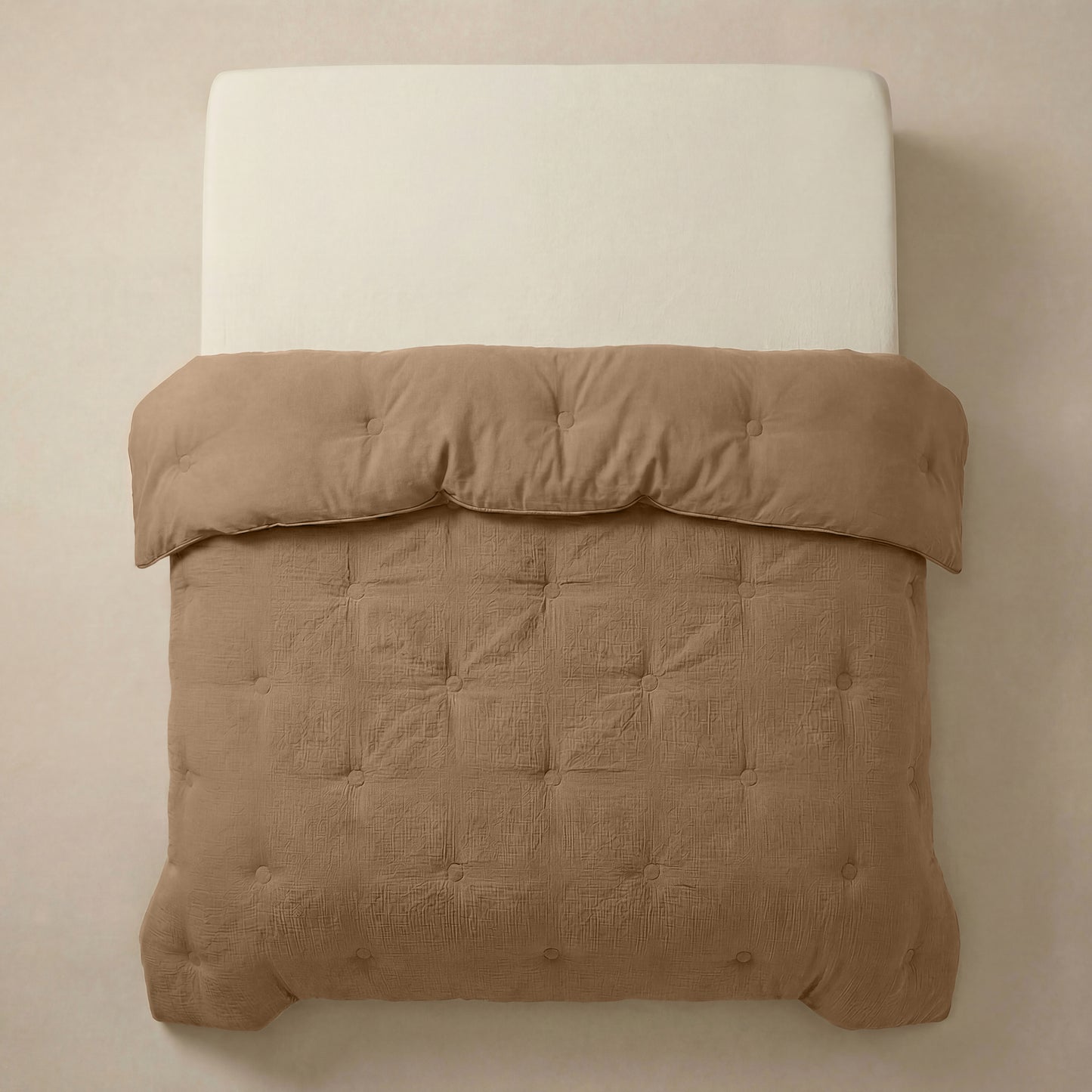 Het Zelesta Japandibed Katoen Mousseline - Bruin is een beige gestoffeerd bed met een crèmekleurige matras, met daarop een lichtbruin, getuft dekbed van zacht mousseline katoen en netjes gerangschikt.