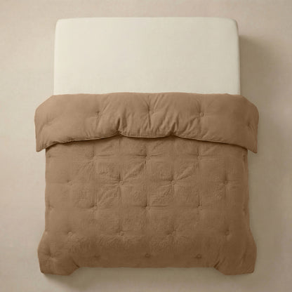 Het Zelesta Japandibed Katoen Mousseline - Bruin is een beige gestoffeerd bed met een crèmekleurige matras, met daarop een lichtbruin, getuft dekbed van zacht mousseline katoen en netjes gerangschikt.