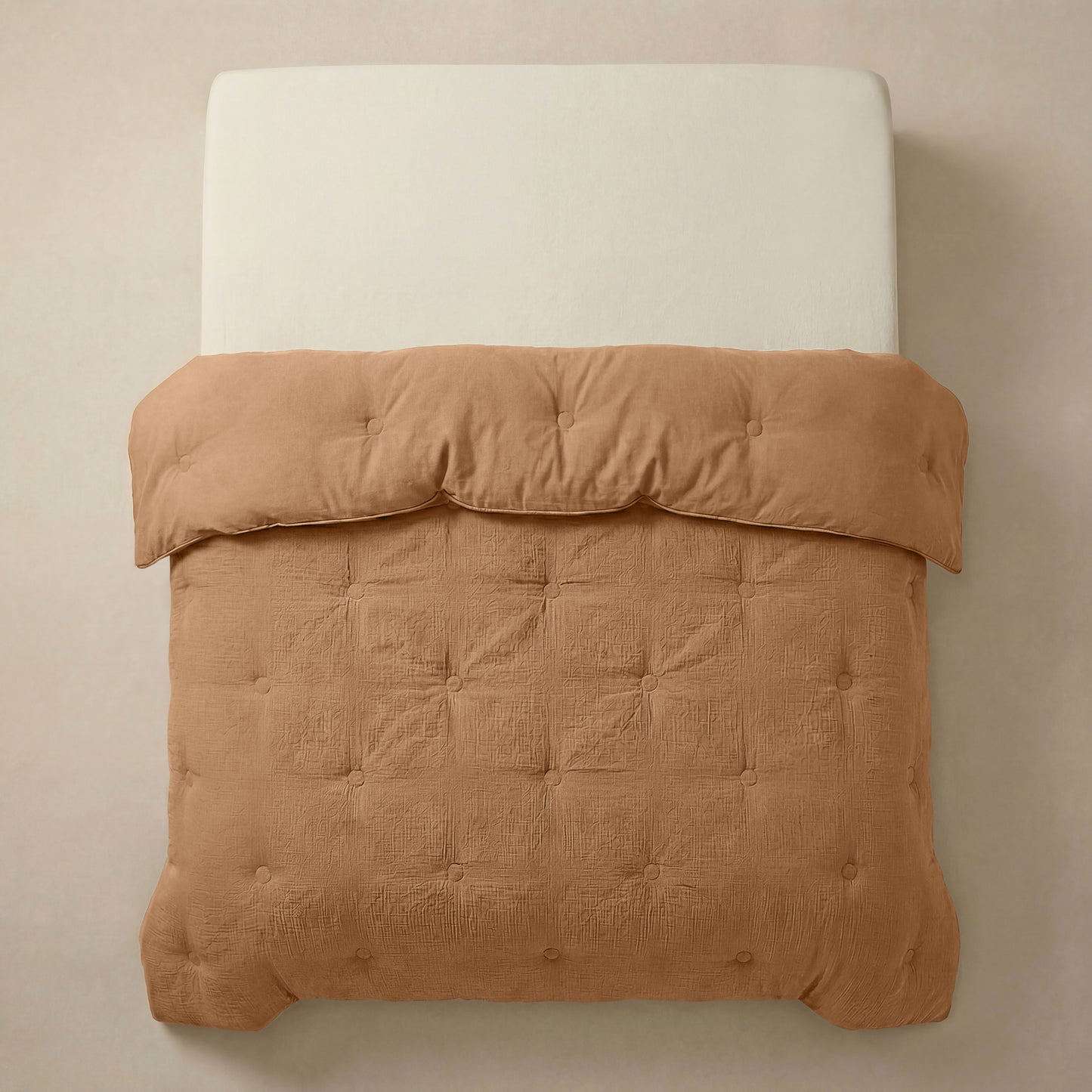 Een keurig opgemaakt bed met een lichtbeige hoofdeinde is voorzien van het Zelesta Japandibed Katoen Mousseline - Terra, een bruin getuft Japandi dekbed, van boven afgebeeld tegen een effen achtergrond.