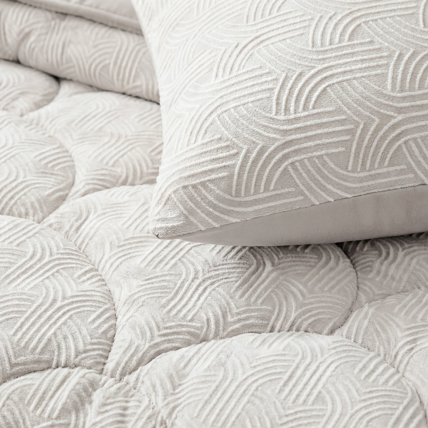 Close-up van Zelesta Flanel Luxe - Crèmekussen en doorgestikt beddengoed met een verhoogd geometrisch patroon in lichtbeige, dat het ultrazachte comfort biedt van een microvezel dekbed.