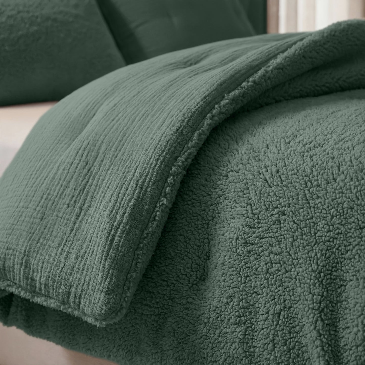 Close-up van een netjes opgemaakt bed met de Zelesta Teddy Katoen Mousseline - Groen, met een gestructureerd, temperatuurregulerend dekbed met pluche sherpa onderkant en bijpassende kussenslopen.