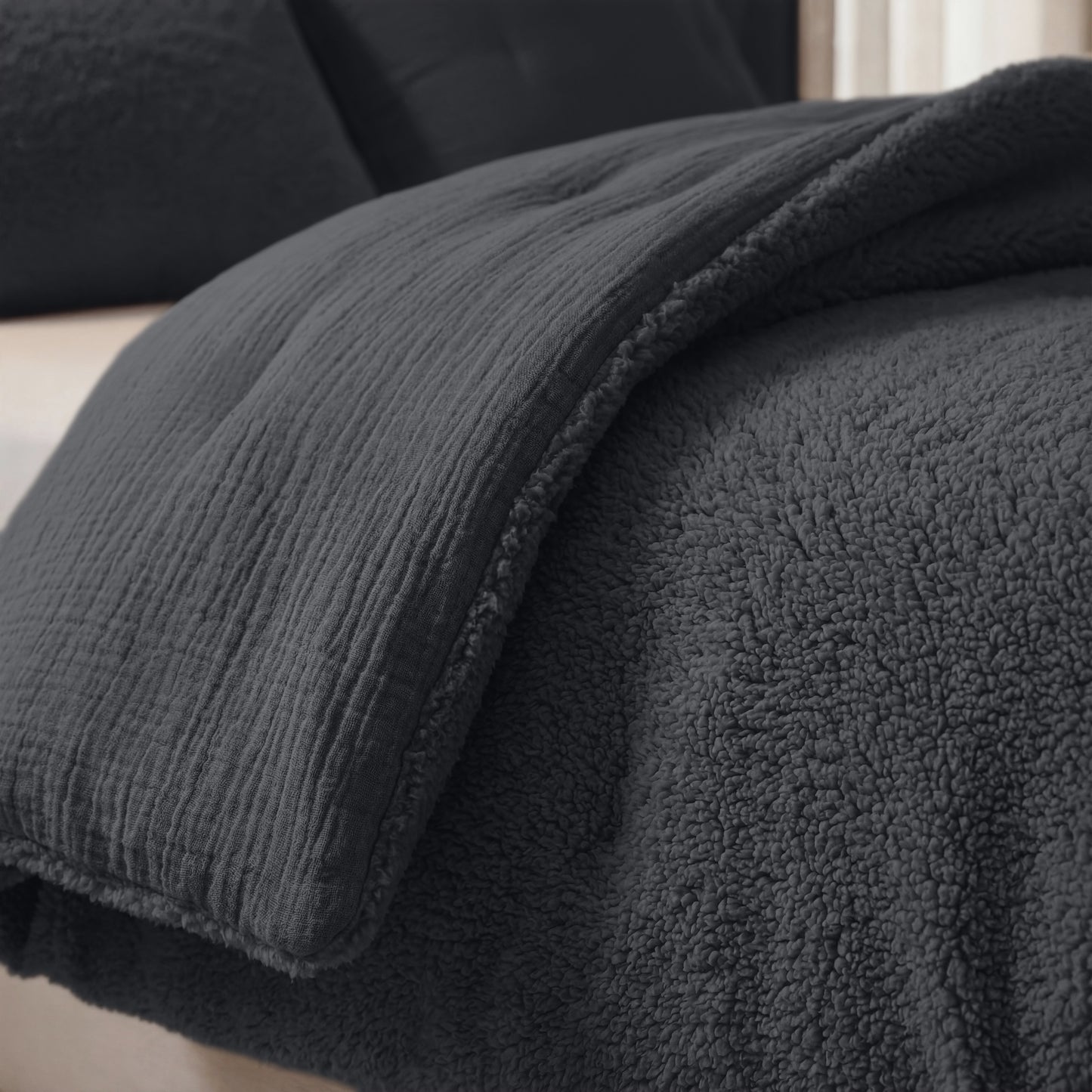 Een close-up van een bed met het Zelesta Teddy Katoen Mousseline - Antraciet dekbed, dat getextureerd, pluche en temperatuurregulerend is voor ultiem comfort.