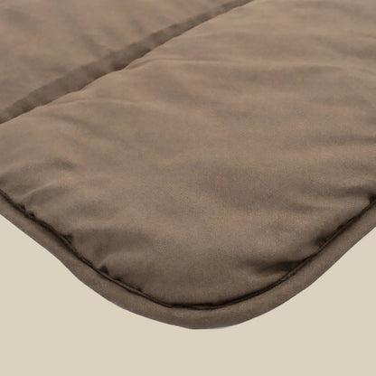 Close-up van het Zelesta Comfort Uni Dekbed - Mokka, een favoriet voor alle seizoenen, met de bruine gewatteerde stof, zachte textuur en afgeronde gestikte hoek tegen een eenvoudige achtergrond.