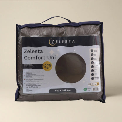 Een verpakte Zelesta Comfort Uni Dekbed - Mokka all season deken in een doorzichtige zak met handvat, met productinformatie en maat 140 x 200 cm op het label.