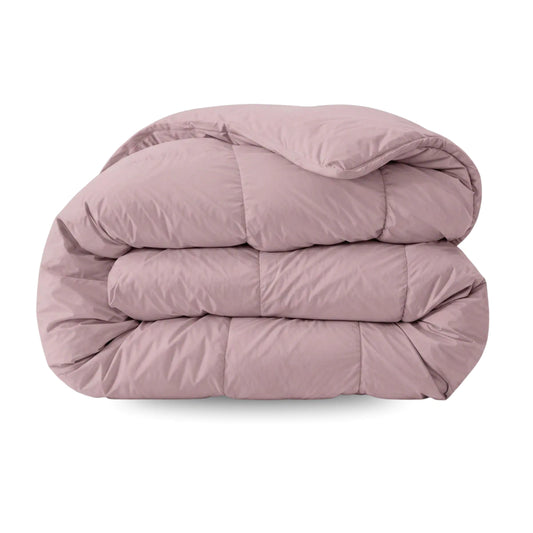 Het Zelesta Comfort Uni Dekbed in oud roze heeft een geplooid, mauve-kleurig doorgestikt dessin dat het hele seizoen comfort en stijl biedt tegen een witte achtergrond.