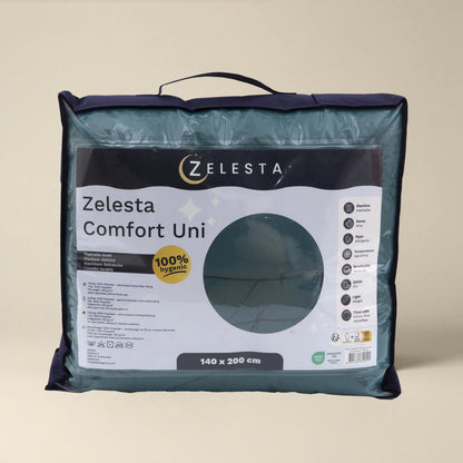 Een verpakt Zelesta Comfort Uni Dekbed - Zeegroen all-season dekbed in een transparante draagtas met handvat, met productgegevens en afmetingen van 140 x 200 cm op het label aan de voorkant.