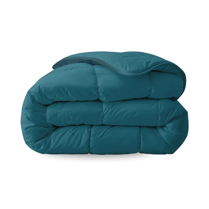 Een netjes opgevouwen marineblauw Zelesta Everyday Uni Dekbed - Nachtblauw met doorgestikt dessin wordt getoond tegen een witte achtergrond - een dekbed en overtrek voor alle seizoenen in één voor veelzijdig comfort.