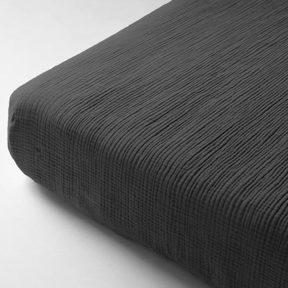Close-up van het Mousseline Hoeslaken - Antraciet, een donkergrijs hoeslaken met een subtiel structuurpatroon, gemaakt van dubbel geweven perkal voor meer comfort en duurzaamheid.