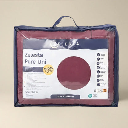 Een verpakt Zelesta Pure Uni Dekbed in bordeaux rood, gelabeld 200 x 200 cm, geaccentueerd voor ademend slaapcomfort met productkenmerken en een 100% hygiënische badge op de voorzijde.