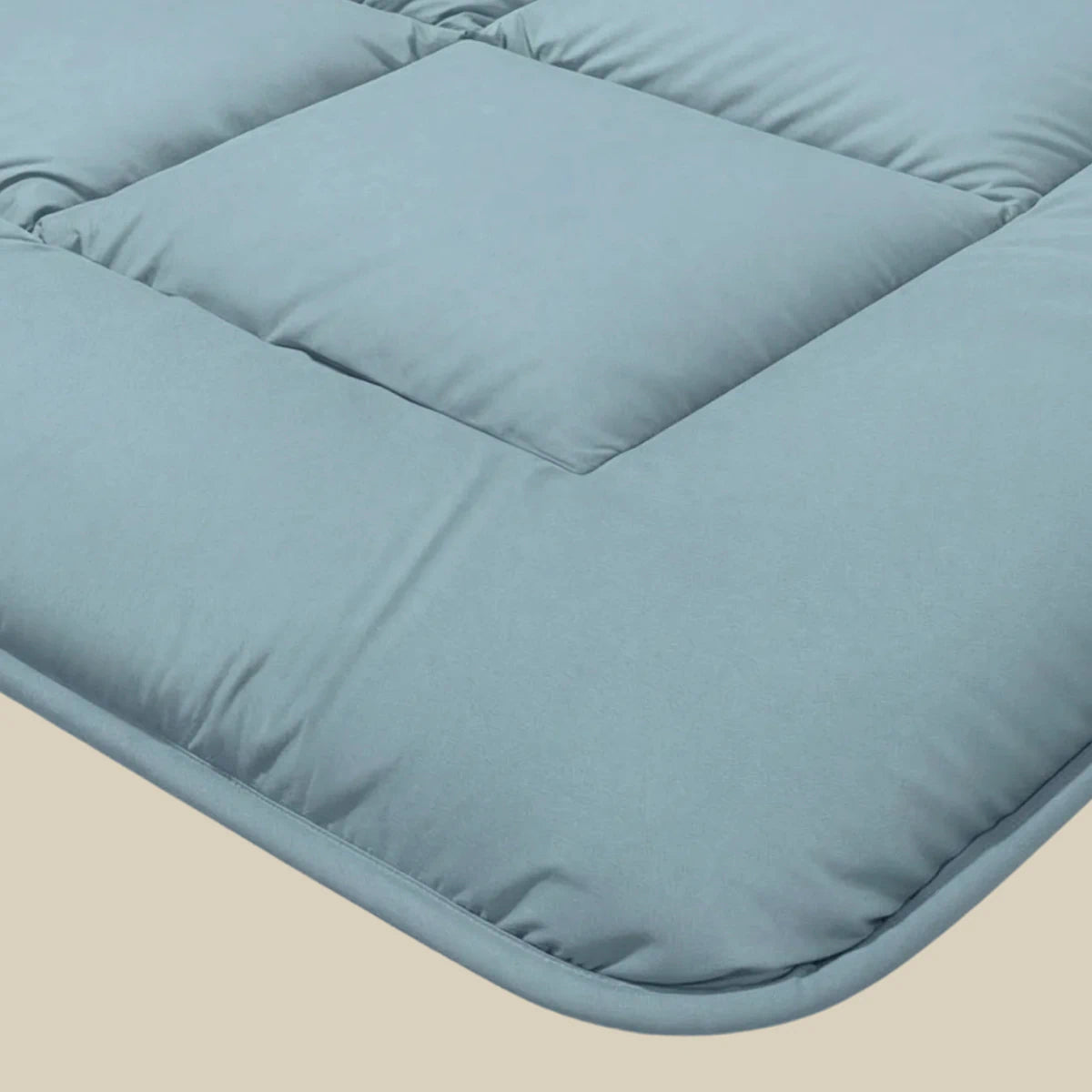 Een close-up van het Zelesta Pure Uni Dekbed in Sereen Blauw, met het lichtblauw gewatteerde vierkante dessin op een neutrale achtergrond voor ademend slaapcomfort.