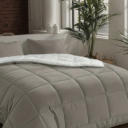 Een netjes opgemaakt bed met het Zelesta Pure Uni Dekbed - Antraciet Grijs in een moderne slaapkamer, omringd door potplanten en een raam met natuurlijk licht voor een ademend slaapcomfort.