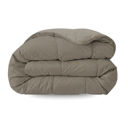 Het Zelesta Pure Uni Dekbed - Antraciet Grijs, met een glad gewatteerd oppervlak, wordt getoond opgevouwen tegen een witte achtergrond en biedt een ademend slaapcomfort voor rustgevende nachten.