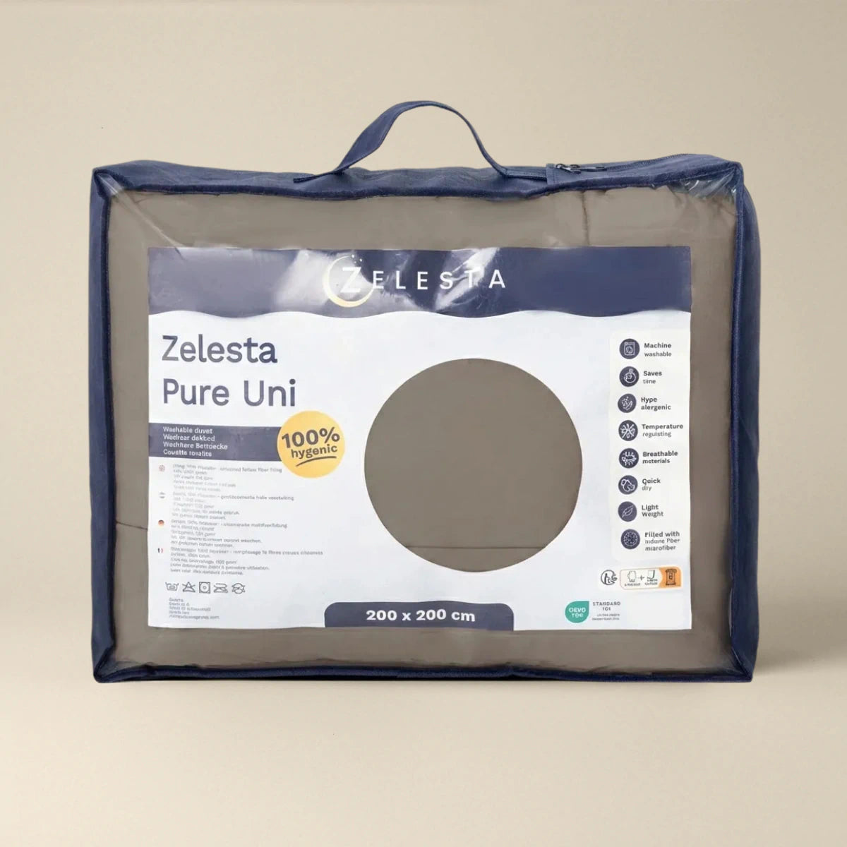 Een verpakt Zelesta Pure Uni Dekbed - Antraciet Grijs, 200 x 200 cm, in een transparante draagtas met productgegevens en pictogrammen op de voorkant, benadrukt ademend slaapcomfort.