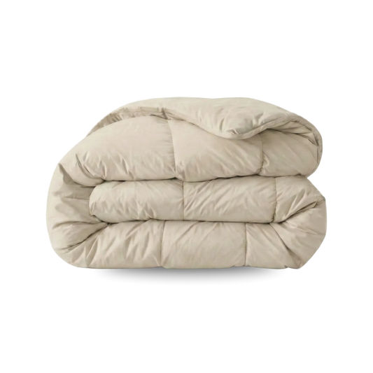 Een Zelesta Wonderbed Katoen - Desert Sand dekbed, gewatteerd en netjes gevouwen op een witte ondergrond, is perfect voor een hotelbeleving slaapkamer en is handig wasbaar.