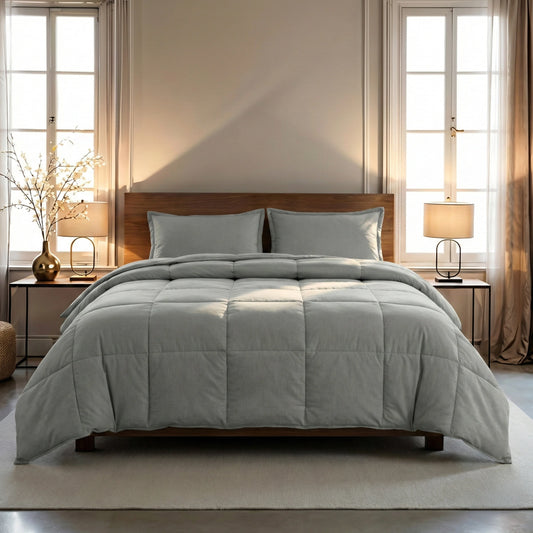 Een keurig opgemaakt bed met een Zelesta Wonderbed 4 Seasons Double Katoen - Morning Grey en bijpassende kussens, geflankeerd door twee nachtkastjes met lampen, in een zacht verlichte slaapkamer met twee ramen.