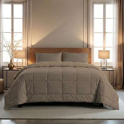 Een netjes opgemaakt bed met het Zelesta Wonderbed 4 Seasons Double in Natural Taupe en twee kussens staat tussen twee ramen, geflankeerd door nachtkastjes met lampen in een zacht verlichte slaapkamer.