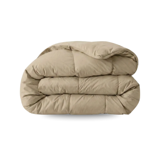Een taupe blush Zelesta Wonderbed Katoen dekbed is netjes gevouwen tegen een witte achtergrond, perfect voor een hotelbeleving slaapkamer en eenvoudig te onderhouden als wasbaar dekbed.