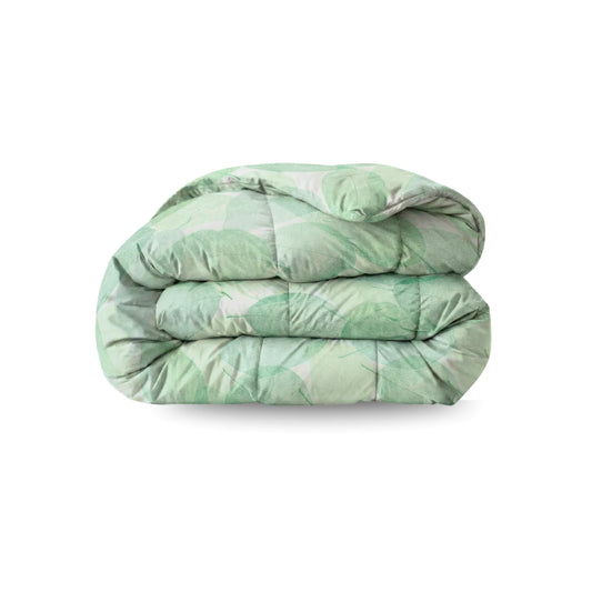 Het Zelesta Wonderbed - Fresh Leaf is een lichtgroen, anti-allergie dekbed met een subtiel bladmotief, netjes gevouwen op een witte achtergrond - ideaal om thuis een verfrissende hotelervaring te creëren.